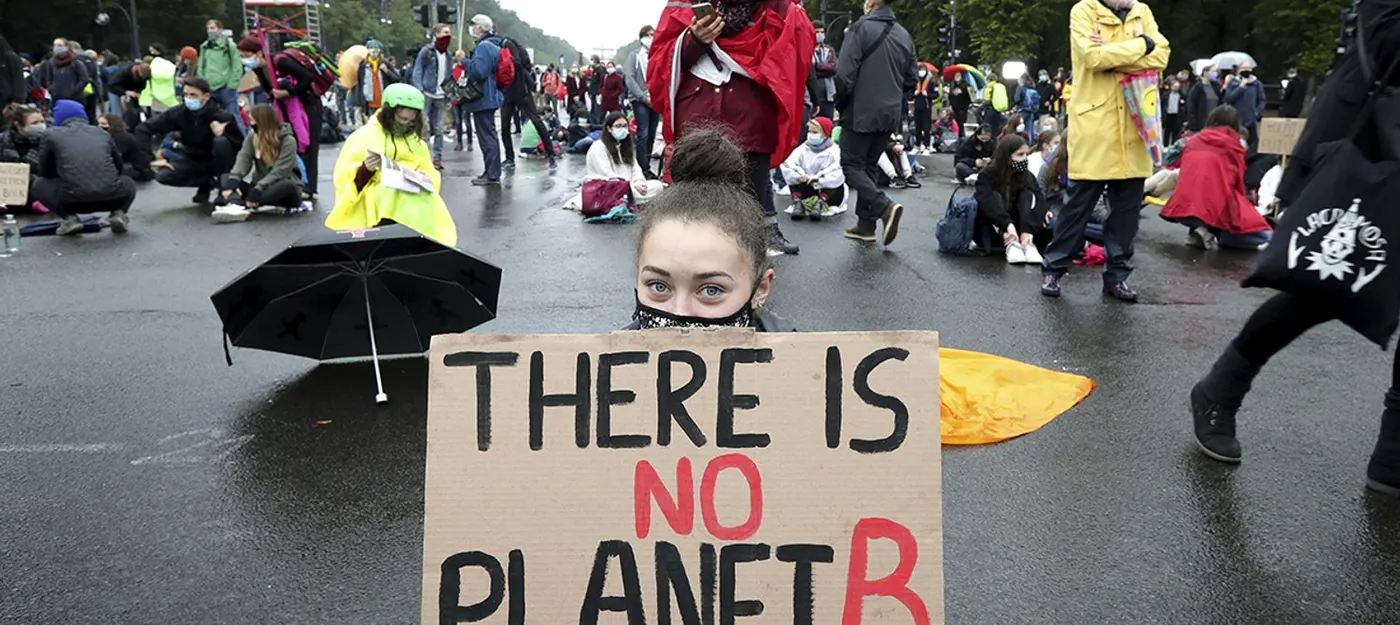 Young climate protesters with a sign reading There is no planet B